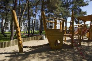 um parque infantil de madeira com escorrega num parque em Nadmorski Dwor Apartament w Gdańsku em Gdansk