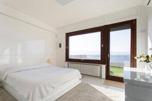 une chambre blanche avec un lit et une grande fenêtre dans l'établissement Reggio Suite, à Reggio de Calabre 75 autres photos