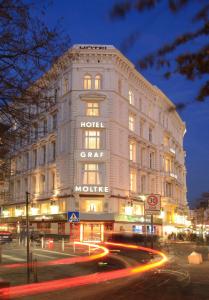 a building with a hotel on the side of it at night at Hotel Graf Moltke Hamburg in Hamburg