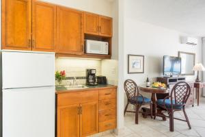 a kitchen with a table and a white refrigerator at Royal West Indies in Grace Bay