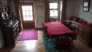 a dining room with a table with a red table cloth at The Old Swan in Cold Ashton