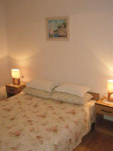sypialnia z łóżkiem z 2 poduszkami i 2 lampami w obiekcie Apartments Baric w Korčuli