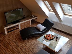a living room with a couch and a table with a bowl of fruit at Old Town Apartment Spilberk in Brno