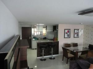 cocina y sala de estar con mesa y sillas en Apartamento Vista Mar 4 Suítes, en Fortaleza