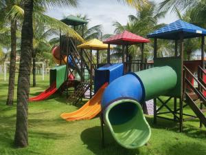 a playground with colorful slides and umbrellas at Resort Aquaville Apartmento in Aquiraz