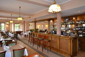 a restaurant with a bar and some tables and chairs at Hotel LOKIS in Niedzica Zamek