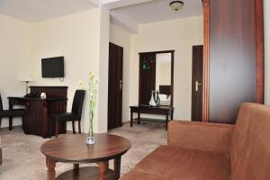 a living room with a couch and a table at Hotel Biały Dwór in Okuninka