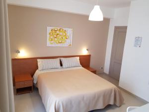 una camera con un grande letto e un dipinto sul muro di B&B Mimosa a Giardini Naxos