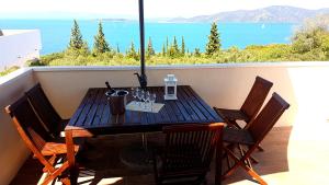 a table on a balcony with a view of the ocean at Captain's Attic in Račišće