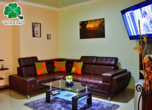 a living room with a brown leather couch and a table at The Clover Home in Palmira