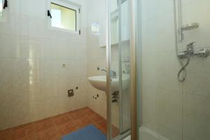 La salle de bains est pourvue d'un lavabo et d'une douche. dans l'établissement Apartments Miskovic, à Vodice