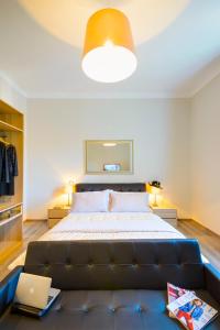 una camera con un grande letto e un divano di RHS Rienzo Suites a Roma