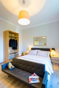 a bedroom with a large bed with a black leather couch at RHS Rienzo Suites in Rome