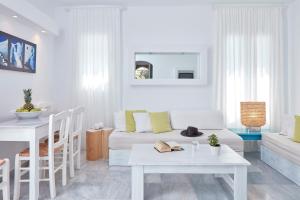 a white living room with a couch and a table at Mykonos Town Suites in Mikonos