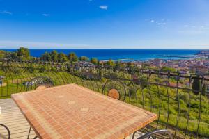 a table on a balcony with a view of the ocean at Casa Marco - Villa alle Cascine - Imperia in Imperia