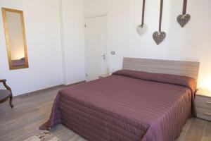 a bedroom with a bed with a purple bedspread at Casa Marco - Villa alle Cascine - Imperia in Imperia