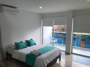 1 dormitorio con 1 cama con 2 toallas en Mayva AprtaHotel en Santa Marta