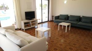 uma sala de estar com dois sofás e uma televisão em Villa V4 Filomena em Mosqueira