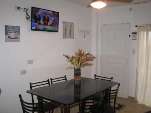 a dining room with a black table and chairs at La Villa Inn in Villa Carlos Paz