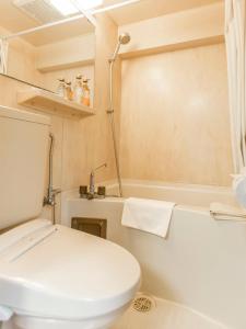a white toilet sitting next to a sink in a bathroom at FLEXSTAY INN Higashi Jujo in Tokyo