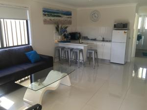 
a living room filled with furniture and a table at Lazy Dayz Shellharbour in Shellharbour

