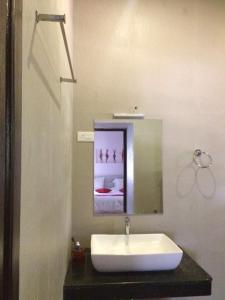 a bathroom with a white sink and a mirror at Sremethila Homestay in Marudhamalai