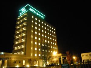 a building with a sign on top of it at night at Hotel Route-Inn Seki in Sekimachi