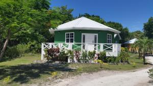 zielony i biały dom przy drodze w obiekcie Cocotal Inn and Cabanas w mieście San Pedro