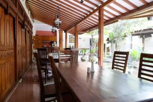 una sala da pranzo con un grande tavolo e sedie in legno di Griya Yunika a Yogyakarta