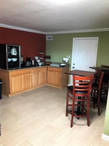 a living room with a table and chairs and a tv at Budget Inn in Sedalia