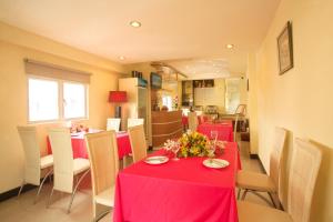 a dining room with red tables and white chairs at Lien An Sai Gon Hotel in Ho Chi Minh City