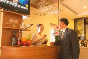 a man and a woman standing at a bar at Lien An Sai Gon Hotel in Ho Chi Minh City