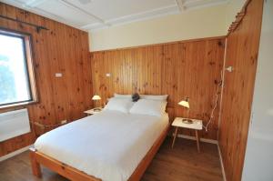 a bedroom with wooden walls and a bed with two lamps at Leski Club in Jindabyne