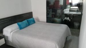 Un dormitorio con una cama con una almohada azul encima. en Bed&Breakfast 10 GIRONA, en Girona
