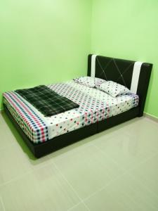 En eller flere senge i et værelse på HR Iman Homestay