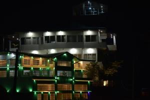 a building lit up at night with green lights at Tea Hills Bungalow in Hatton