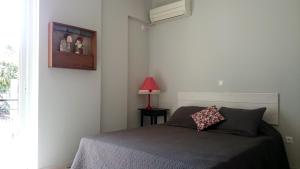 サミにあるEleni Apartmentのベッドルーム1室(ベッド1台、ランプ、窓付)