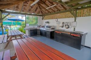 an open kitchen with a table and a bench at Apollo Luxury Apartments in Merimbula
