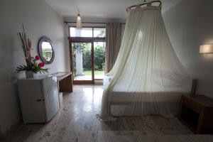 a bedroom with a bed with a mosquito net at Ecosfera Hotel & Spa in Canggu