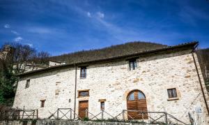 un gran edificio de piedra con techo de hierba en Le Aie Di Postignano, en Sellano