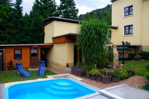 a swimming pool in the yard of a house at Ferienhaus und Ferienwohnung Büttner in Rathmannsdorf