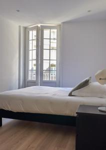 サン・マロにあるL'Annexeのベッドルーム1室(大型ベッド1台、窓2つ付)