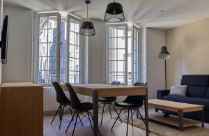 a living room with a table and chairs and a couch at L'Annexe in Saint Malo