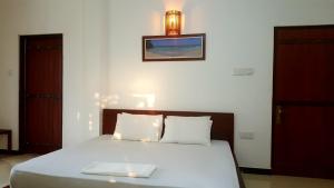 a bedroom with a bed with a plate on it at Villa Happy Home in Bentota