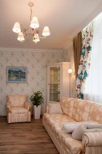 Vysotnik Hotel في تشيليابنسك: غرفة معيشة مع أريكة وكرسي
