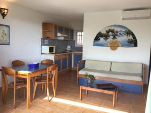 ein Zimmer mit einem Bett und einem Tisch und einer Küche in der Unterkunft Villa Les Hameaux Di Santa Giulia in Porto-Vecchio