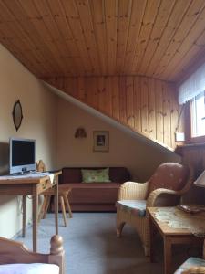a living room with a couch and a desk at Haus am Wald in Bayerisch Eisenstein