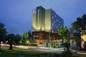 チカランにあるBATIQA Hotel Jababeka Cikarangの夜の街路にある高層ビル