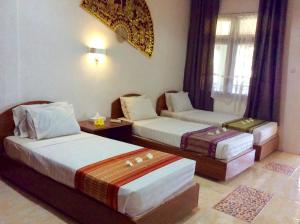 a hotel room with two beds and a couch at Pasific Beach Cottages in Senggigi