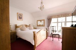 a bedroom with a large bed and a window at The White Hart Inn in Winchcombe